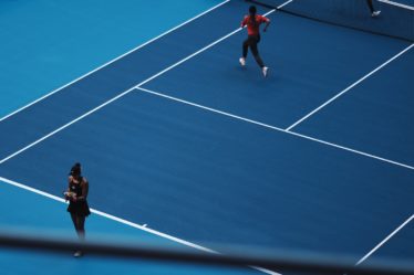 two person playing tennis during daytime